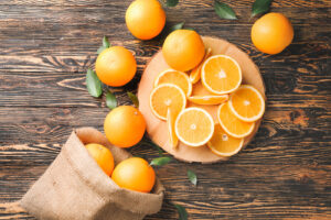Oranges fraîchement coupées disposées sur une planche à découpée posée sur une table en bois.
